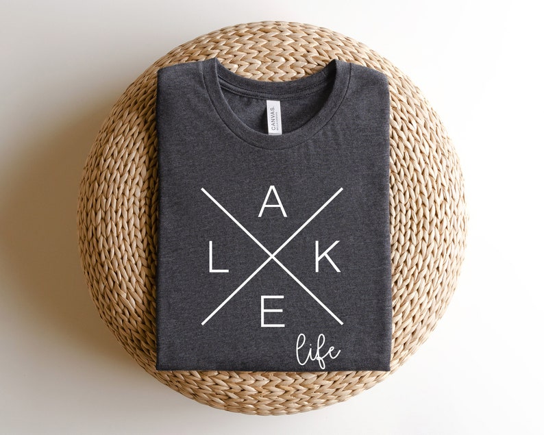 May include: A dark gray t-shirt with a white graphic design that says "LAKE life" with the letters "LAKE" forming a cross.