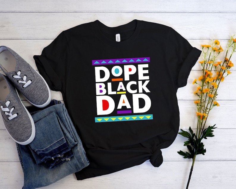 May include: Black t-shirt with the text "Dope Black Dad" in a colorful retro style.