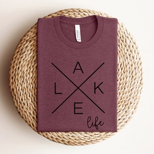 May include: A maroon t-shirt with a black graphic design that says "LAKE life" in a stylized font.
