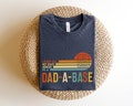 I Keep All My Dad Jokes In A Dad-a-base Shirt,New Dad Shirt,Dad Shirt,Daddy Shirt,Father's Day Shirt,Best Dad shirt,Gift for Dad product logo