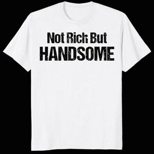Puede incluir: Camiseta blanca con el texto negro "Not Rich But Handsome". El texto está en negrita. La camiseta tiene mangas cortas y cuello redondo.
