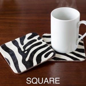 hair on hide zebra print , on a wooden table , eludes luxury soho home decor