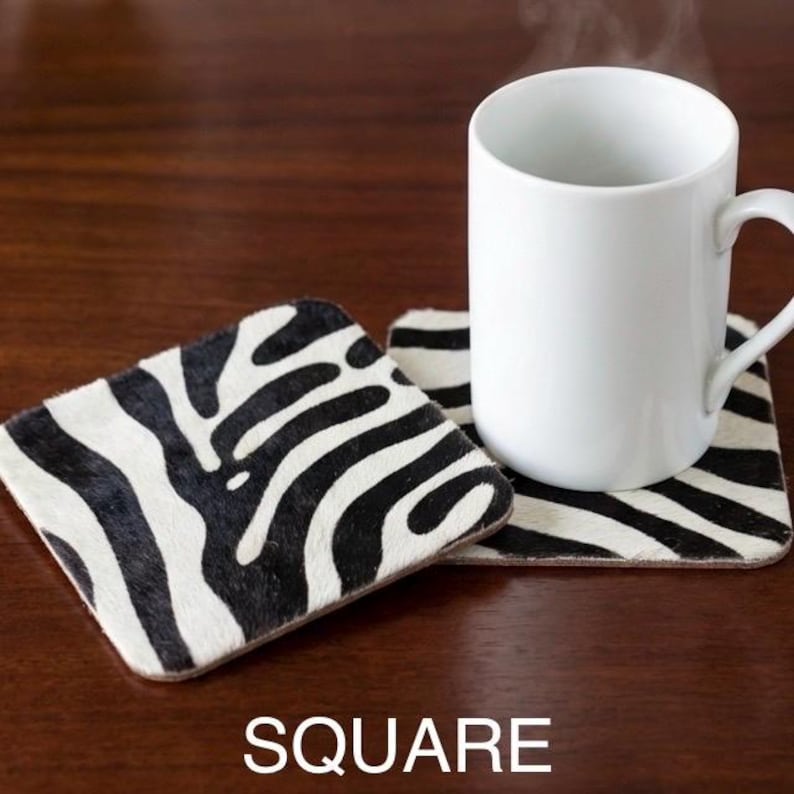 hair on hide zebra print , on a wooden table , eludes luxury soho home decor