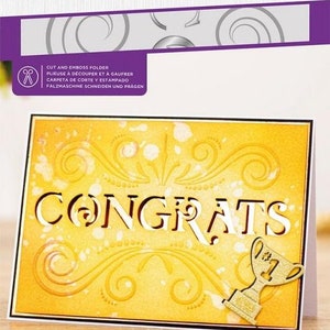 May include: A yellow die-cut card with a gold trophy and the word "CONGRATS" in a decorative font. The card is 5 inches by 7 inches and is part of a die-cut and emboss folder set.