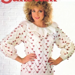 May include: White knitted sweater with a white collar and red bobbles. The sweater has a lacy pattern and is shown on a model. The text "Sunbeam" is in the top left corner of the image. The text "830 Mohair or Sumatra 81-107 cm bust 32-42 ins" is in the top right corner of the image.
