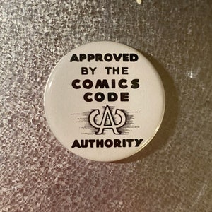 May include: A white button with black text that reads "APPROVED BY THE COMICS CODE AUTHORITY" and a black logo with the letters "CA" inside a circle.