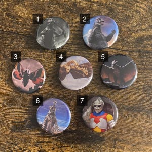 May include: Seven round buttons with different images of monsters and creatures. The buttons are numbered 1 through 7. The images include a moth, a dragon, a monster with wings, a Godzilla-like monster, a creature with a long neck, and a robot.