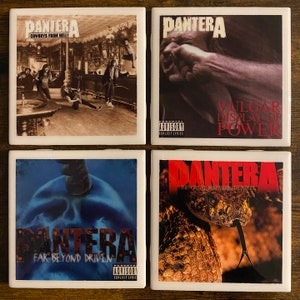 May include: Set of four square coasters featuring album covers from the band Pantera. The coasters feature the album titles "Cowboys From Hell", "Vulgar Display of Power", "Far Beyond Driven", and "The Great Southern Trendkill".