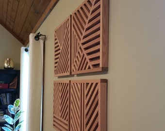 Op de afbeelding: Vier houten wandpanelen met een geometrisch patroon. De panelen zijn in een vierkante vorm gerangschikt en zijn gemaakt van lichtbruin hout.