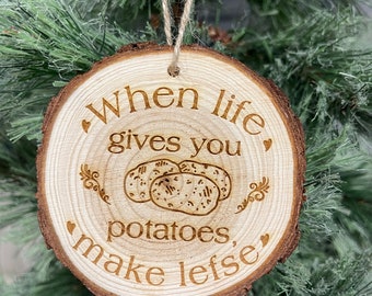 Puede incluir: Adorno de Navidad de madera con el texto "When life gives you potatoes, make lefse".