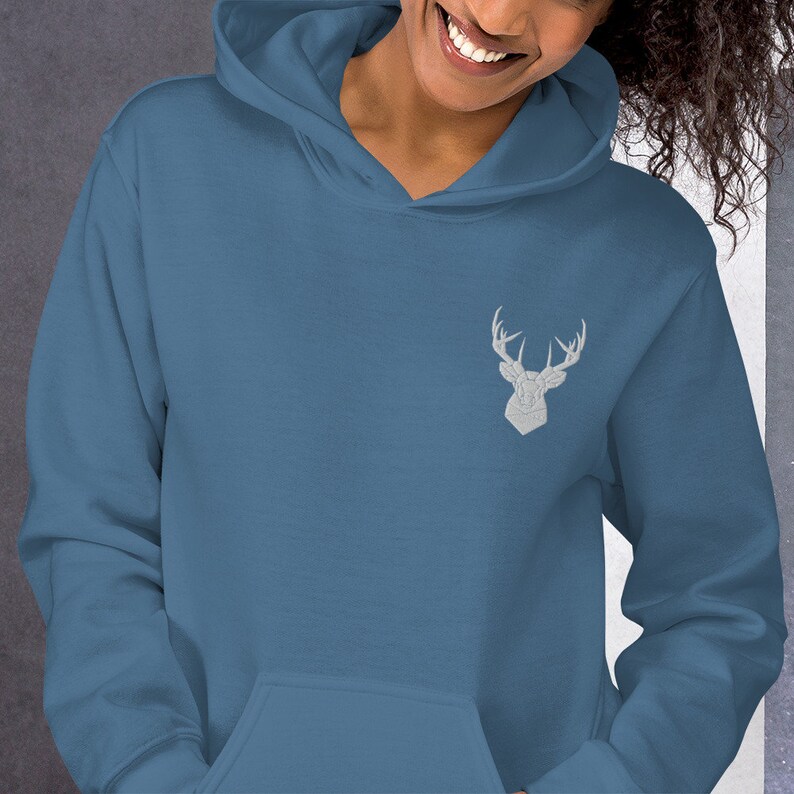 May include: A blue hooded sweatshirt with a white embroidered deer head design on the front.