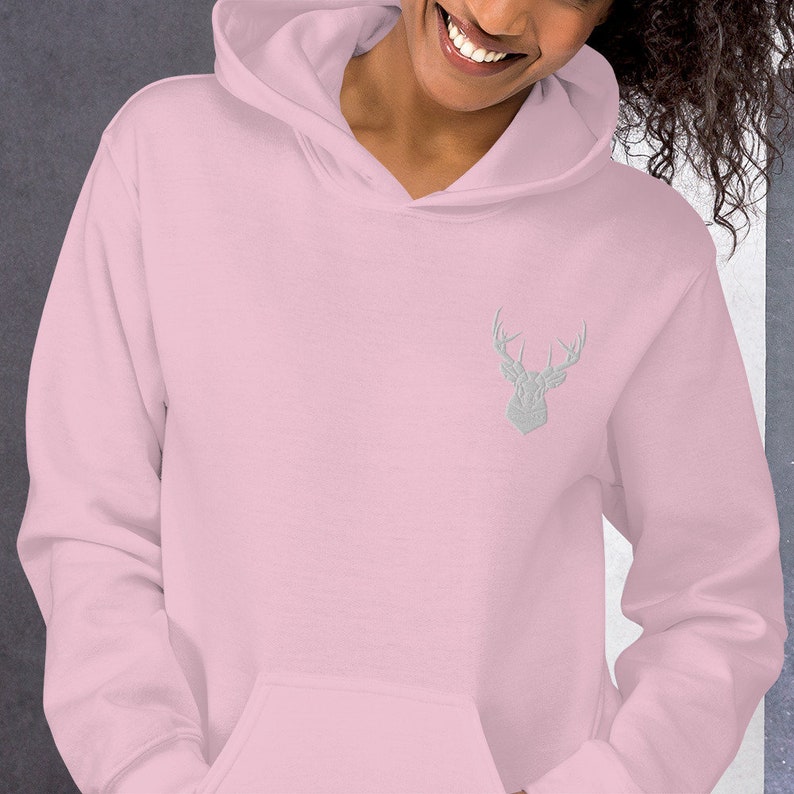 May include: A pink hoodie with a silver embroidered deer head on the front.