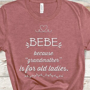 May include: A maroon t-shirt with a white graphic that says "BEBE because "grandmother" is for old ladies."