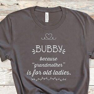 May include: A dark grey t-shirt with white text that reads "Bubby because "grandmother" is for old ladies."