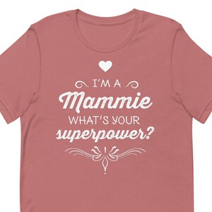 Puede incluir: Una camiseta rosa con texto blanco que dice "I'm a Mammie What's your superpower?" con un símbolo de corazón sobre la palabra "Mammie".