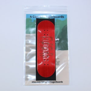 May include: A red fingerboard with black trucks and wheels. The fingerboard is in a clear plastic bag with a white label that says "4 Corner Fingerboards" and "etsy.com/shop/4CFingerboards".