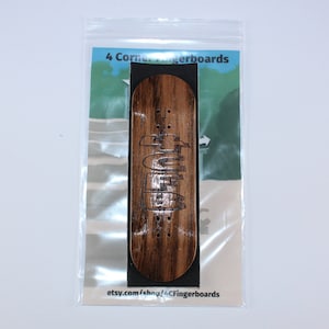 May include: A wooden fingerboard with the text "4 Corner Fingerboards" and the website address "etsy.com/shop/4CornerFingerboards" printed on the packaging.