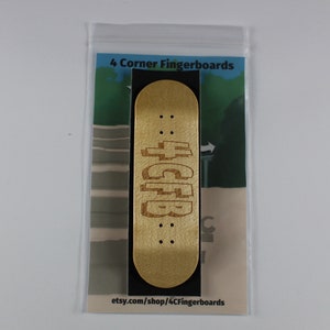 May include: A wooden fingerboard with the text "4CFP" engraved on it. The fingerboard is in a clear plastic bag with a white background and the text "4 Corner Fingerboards" and "etsy.com/shop/4CornerFingerboards" printed on it.