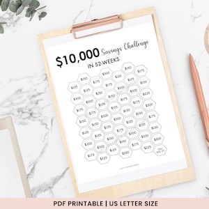 May include: A printable savings challenge chart with a honeycomb design. The chart is titled "$10,000 Savings Challenge in 52 Weeks". Each hexagon contains a dollar amount, starting with $125 and increasing to $300.