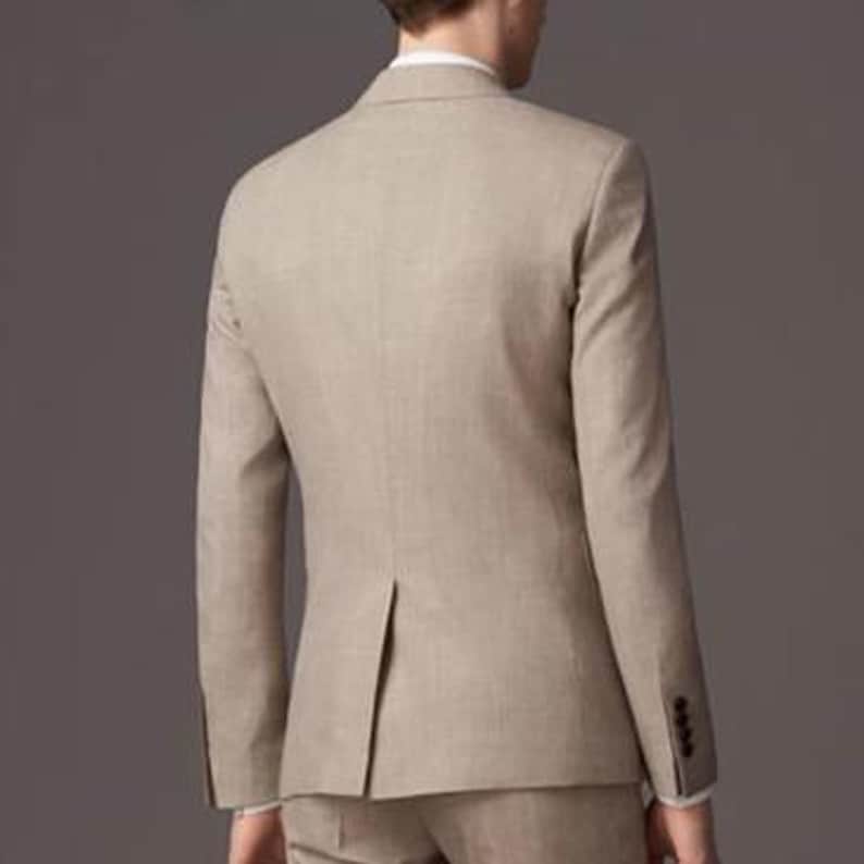 May include: A beige suit jacket with a single button closure. The jacket has a classic fit and a smooth texture.