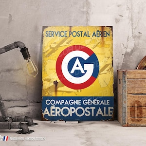 Puede incluir: Un letrero de metal de estilo vintage con fondo amarillo y un círculo rojo, blanco y azul con las letras "A.G." en el centro. El letrero dice "Service Postal Aérien Compagnie Générale Aéropostale".