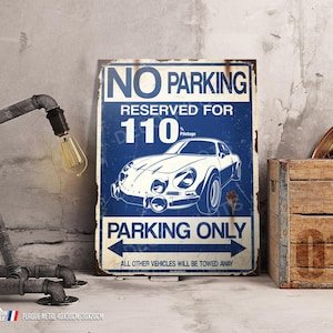 Könnte beinhalten: Blaues und weißes Metallschild mit dem Text "NO PARKING RESERVED FOR 110 Pilotage PARKING ONLY ALL OTHER VEHICLES WILL BE TOWED AWAY". Das Schild zeigt eine blaue und weiße Illustration eines Oldtimers.