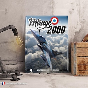 Op de afbeelding: Een metalen bord met een blauwe en grijze Mirage 2000 straaljager die door wolken vliegt. Het bord heeft de tekst "Mirage 2000" in zwart en wit met een rode cirkel en een witte stip in de rechterbovenhoek. De tekst "Aviation Militaire Française" staat onderaan het bord.