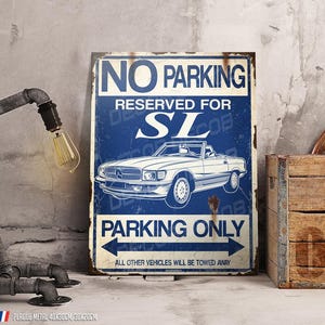 Può includere: Un cartello in metallo in stile vintage con sfondo blu e testo bianco "NO PARKING RESERVED FOR SL". Il cartello presenta un'illustrazione di un'auto d'epoca e "PARKING ONLY". Una lampada decorativa e una cassa di legno sono accanto al cartello. Misura 40x30cm.