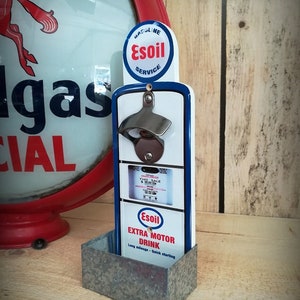 Blue and white "Esoil" wall-mounted bottle opener, vintage gas pump style decoration.