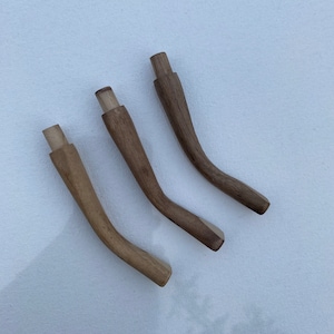 May include: Three wooden chair legs with a curved shape. The legs are made of light brown wood and have a natural finish.