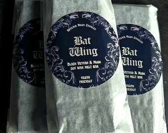 May include: Three wrapped soy wax melt bars. Each bar is wrapped in white paper and has a circular label with the text "Bat Wing" and "Black Vetiver & Musk Soy Wax Melt Bar". The labels also state "Vegan Friendly".