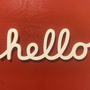 Könnte beinhalten: Weiße kursive Schrift, die "hello" auf einem roten Hintergrund buchstabiert.