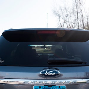 May include: Rear view of a gray Ford Explorer SUV with a sticker on the back window. The sticker reads "I STARE AT BOOBS ALL DAY." and "#lactation consultant."