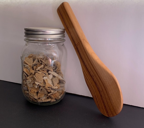 A hand-turned applewood spurtle — a genuinely niche Scottish kitchen tool most people have never heard of, made from a single piece of real fruit wood with grain and character unique to every piece.