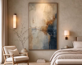 May include: A large rectangular wall art piece featuring an abstract composition of blended cream, beige, deep navy blue, and metallic gold tones. The painting displays textured brushstrokes and layered color gradients within a thin gold frame.