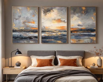 May include: A triptych of three rectangular wall art canvases featuring an abstract landscape painting with thick, textured brushstrokes in shades of gray, white, deep blue, and vibrant orange, all framed in thin, metallic gold-toned borders.