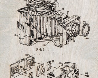 May include: A vintage black and white patent illustration of a photographic camera accessory, dated May 31, 1966. The detailed drawing shows the camera's components, including the lens, body, and internal mechanisms, on a light wood background.