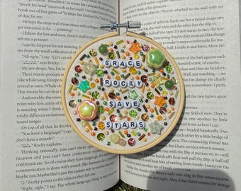 Adorno decorativo con cuentas inspirado en el proyecto Ave María y con temática literaria.
