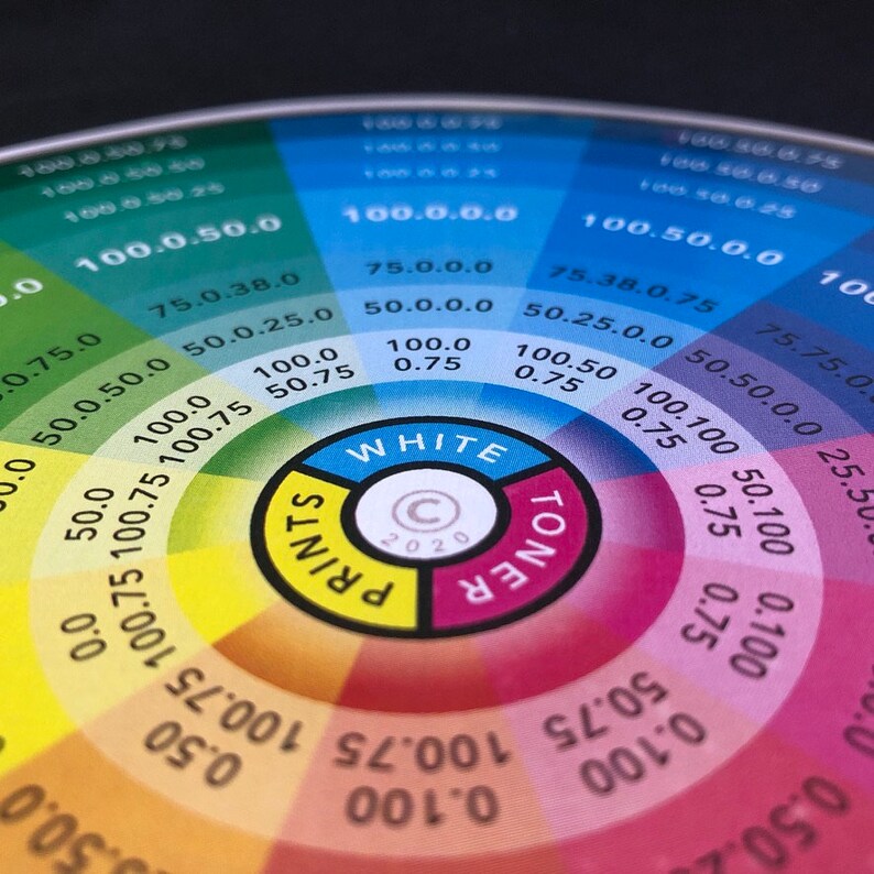 Pode incluir: Uma roda de cores com um centro circular etiquetado como "WHITE" e "TONER" com um s&iacute;mbolo de direitos autorais e o ano 2020. A roda &eacute; dividida em se&ccedil;&otilde;es de cores com n&uacute;meros e percentagens para cada cor. As cores s&atilde;o amarelo, laranja, vermelho, rosa, roxo, azul, verde e amarelo.