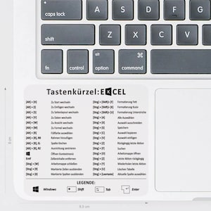 May include: A white sheet of paper with a black and white keyboard illustration and a list of keyboard shortcuts for Microsoft Excel. The text reads "Tastenkürzel: EXCEL" and includes keyboard shortcuts for common actions like "Zu Start wechseln", "Zu Einfügen wechseln", "Zu Seitenlayout wechseln", "Zu Daten wechseln", "Zu Ansicht wechseln", "Zu Formel wechseln", "Füllfarbe auswählen", "Rahmen hinzufügen", "Spalte löschen", "Ausrichtung zentrieren", "Öffnen Kontextmenü", "Zelleninhalte entfernen", "Arbeitsmappe schließen", "Markierte Zeilen ausblenden", "Markierte Spalten ausblenden". The sheet also includes a legend with the symbols for Windows, Shift, Tab, and Enter.