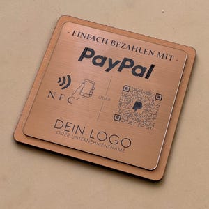 Op de afbeelding: Een vierkant koperkleurig betaalbordje met de tekst EINFACH BEZAHLEN MIT PayPal, een NFC-icoon, een QR-code en de placeholdertekst DEIN LOGO ODER UNTERNEHMENSNAME. Het bordje heeft een metallic afwerking op een bruine ondergrond.