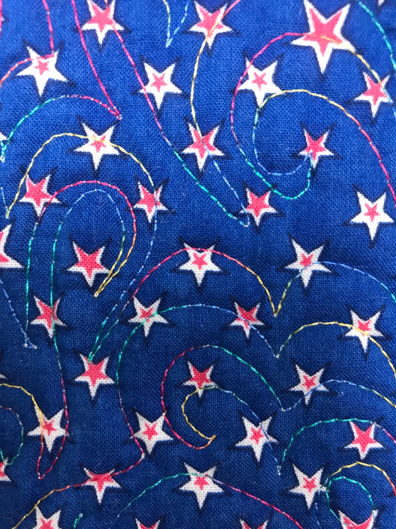 May include: Blue fabric with a white and red star pattern. The stars are connected by colorful, wavy lines.