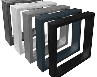 Op de afbeelding: Vijf vierkante fotolijsten in verschillende kleuren, van links naar rechts: zwart, donkerblauw, lichtgrijs, middelgrijs en wit. De lijsten zijn in elkaar genest, met de grootste lijst links en de kleinste lijst rechts.