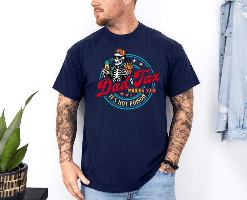 Pode incluir: Camiseta azul marinho com um gr&aacute;fico que diz "Dad Tax" em escrita vermelha, apresentando um esqueleto segurando uma bebida e batatas fritas. O design inclui o texto "Making Sure It's Not Poison" em um padr&atilde;o circular.