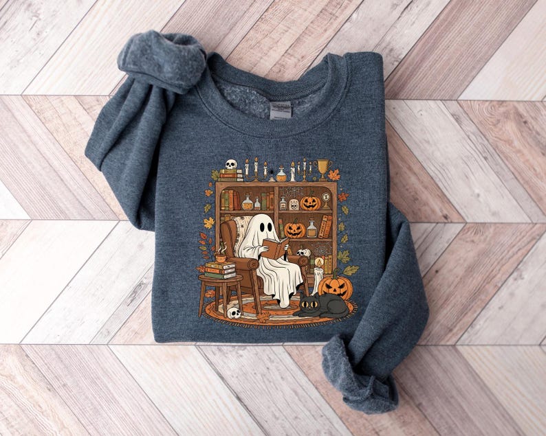 Peut inclure: Un sweat-shirt bleu marine avec un motif d'Halloween. Le dessin repr&eacute;sente un fant&ocirc;me lisant dans un fauteuil, avec des citrouilles, des bougies et un chat noir. Le sweat-shirt est fait d'une mati&egrave;re douce.