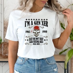 Op de afbeelding: Wit T-shirt met een zwarte schedel afbeelding en de tekst "I'M A GEN XER 1965 1980 SO IF YOU DON'T WANT YOUR FEELINGS HURT WALK AWAY".
