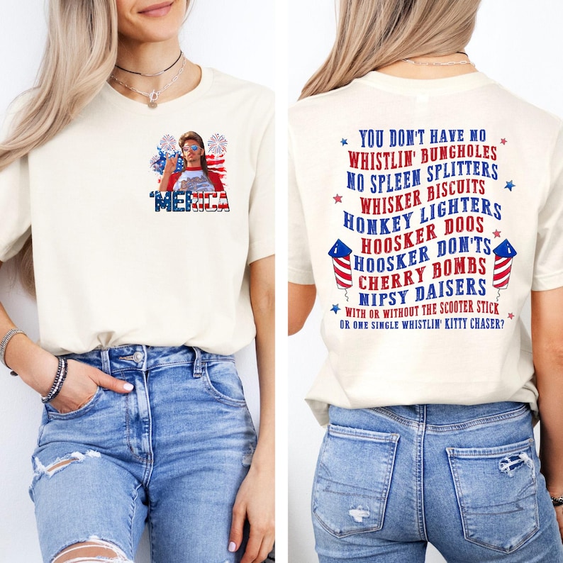 Pode incluir: Camiseta creme com a palavra "'MERICA" em vermelho, branco e azul, com um gr&aacute;fico de uma mulher usando &oacute;culos de sol e fogos de artif&iacute;cio. A parte de tr&aacute;s da camisa tem uma lista de frases humor&iacute;sticas.