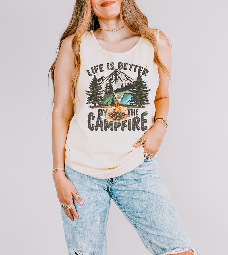 May include: A yellow tank top with a graphic print of a mountain scene with the text "Life is better by the campfire".
