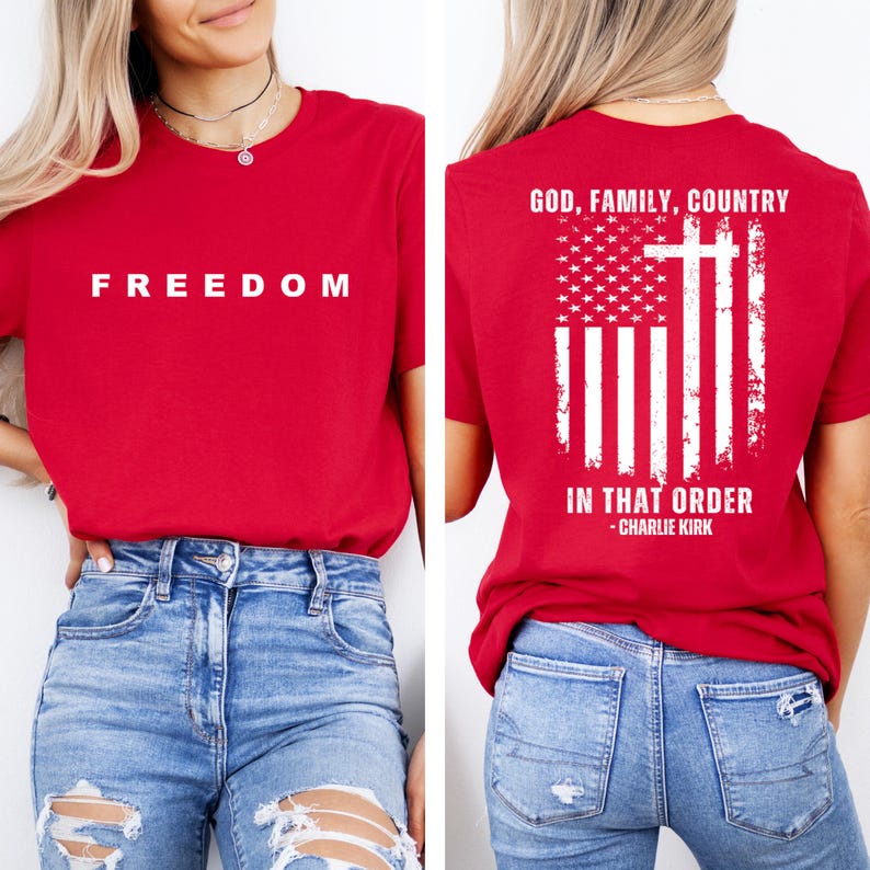 May include: Red t-shirt with the word "FREEDOM" in white block letters on the front. The back of the shirt features an American flag design with a cross and the text "GOD, FAMILY, COUNTRY IN THAT ORDER - CHARLIE KIRK."