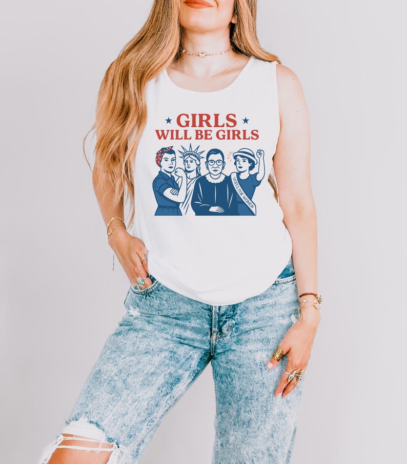 May include: White tank top with the text "GIRLS WILL BE GIRLS" in red and blue. The graphic features illustrations of four women in blue, including Rosie the Riveter, the Statue of Liberty, Ruth Bader Ginsburg, and a woman with a "VOTE FOR WOMEN" sash.